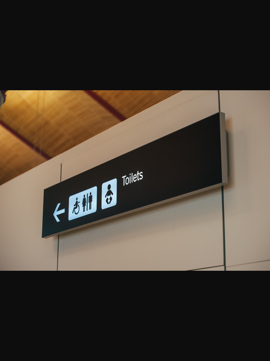 Restroom directional sign, installed interior