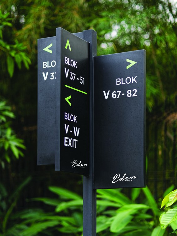 Black directional totem among planting